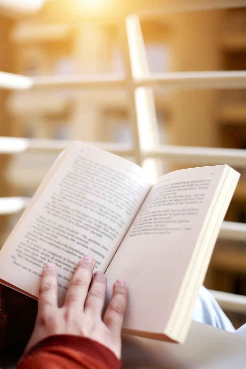 Close up image of hands holding open a book.