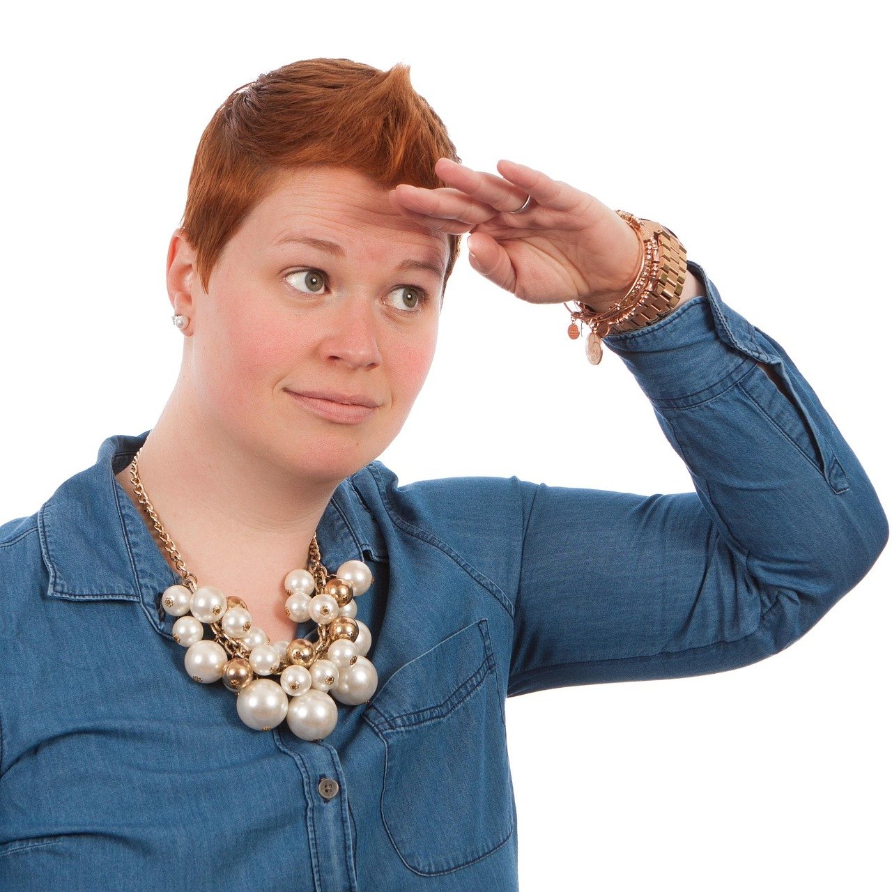Stock image of a silly red-haired woman looking for someone in the distance.